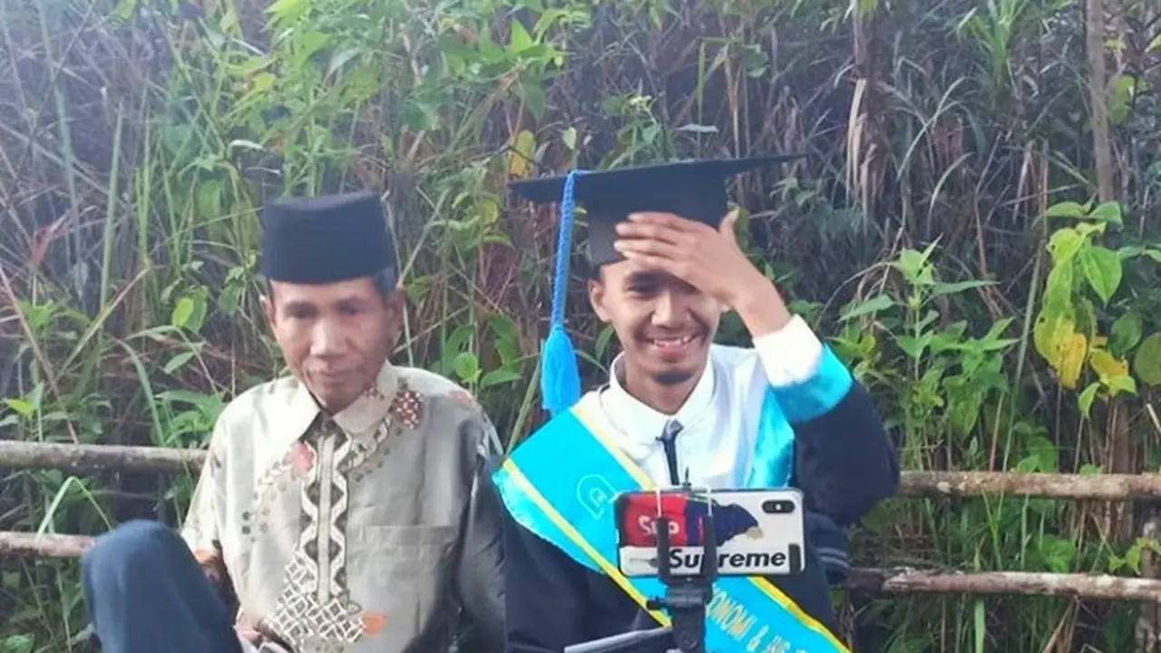 Ahmad Krismon bersama ayahnya saat wisuda online di perbukitan Kabupaten Agam. (Liputan6.com/ dok instagram @bukittinggisorak)