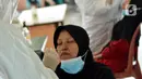 Petugas medis mengambil sampel lendir saat tes swab PCR massal di Kantor Kecamatan Pancoran Mas, Depok, Selasa (5/1/2021). Puskesmas Pancoran Mas melakukan tes Swab PCR kepada warga yang pernah memiliki riwayat kontak erat dengan pasien terkonfirmasi positif Covid-19. (merdeka.com/Arie Basuki)