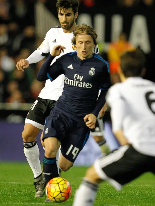 Gelandang Valencia, Andre Gomes (kiri) berusaha merebut bola yang dibawa gelandang Real Madrid, Luka Modric  pada lanjutan liga Spanyol di stadion Mestalla, (3/1/2015). Real Madrid bermain imbang dengan Valencia dengan skor 2-2. (AFP/JOSE JORDAN)
