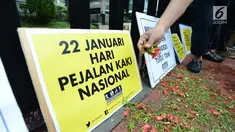Aktivis Koalisi Pejalan Kaki tabur bunga untuk memperingati Hari Pejalan Kaki Nasional di kawasan Tugu Tani, Jakarta, Selasa, (22/1). Acara ini sekaligus mengenang 9 pejalan kaki yang gugur akibat kecelakaan pada 2012 lalu. (Merdeka.com/Imam Buhori)