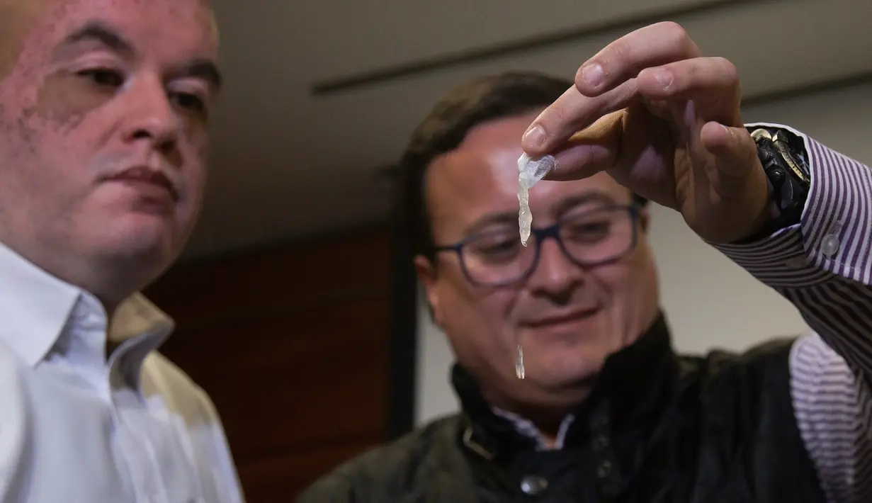 Insinyur Chile, Roberto Astete dan Christian Olivares menunjukkan tas plastik karya mereka bisa larut dalam air di Santiago, Selasa (24/7). Tas inovatif itu bisa menjadi pengganti plastik-plastik yang selama ini mencemari lingkungan. (AFP/CLAUDIO REYES)