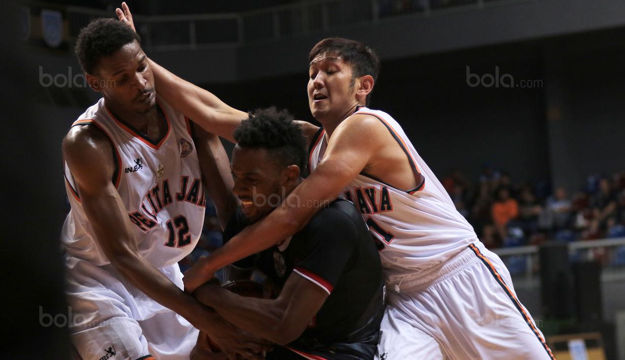 Pemain Hangtuah Sumsel, Palmore Keenan (tengah) berusaha keluar dari adangan dua pemain Pelita Jaya pada laga Perbasi Cup 2017 di Sports Mall, Kelapa Gading, Jakarta, (09/11/2017). Pelita Jaya menang 67-58. (Bola.com/Nick Hanoatubun)