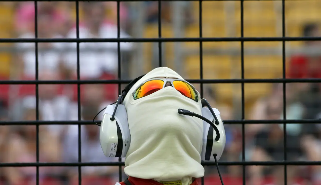 Seorang penjaga garis melihat keatas saat sesi latihan Grand Prix Singapura F1 (18/9/2015). Kabut asap yang menyelimuti sirkuit tak menyurutkan pembalap untuk tetap melakukan pemanasan. (REUTERS/Edgar S)