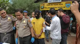 Petugas menghadirkan tersangka pelaku pembunuhan berencana yang terjadi di Kolong Tol Sedyatmo karena tidak terima pacarnya dilecehkan, di halaman markas Polsek Metro Penjaringan, Jakarta, Selasa (7/7/2015). (Liputan6.com/Faizal Fanani) 