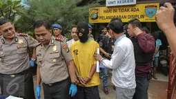 Petugas menghadirkan tersangka pelaku pembunuhan berencana yang terjadi di Kolong Tol Sedyatmo karena tidak terima pacarnya dilecehkan, di halaman markas Polsek Metro Penjaringan, Jakarta, Selasa (7/7/2015). (Liputan6.com/Faizal Fanani) 