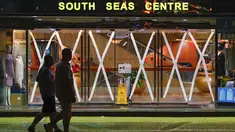 Warga berjalan melewati sebuah pusat perbelanjaan yang pintu kacanya ditempel sebagai tindakan pencegahan terhadap Topan Super Saola yang mendekat, pada pagi hari, di Hong Kong, Jumat (1/9/2023). (AP Photo/Daniel Ceng)