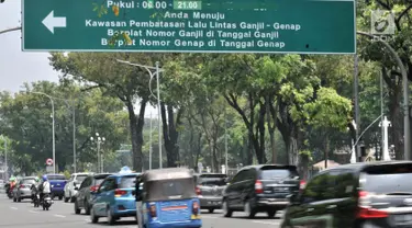 Kendaraan melintas di bawah rambu pemberitahuan sistem ganjil genap di Jalan Medan Merdeka Utara, Jakarta, Senin (3/9). Pemprov DKI Jakarta melalui Pergub Nomor 92 Tahun 2018 memperpanjang waktu sistem ganjil genap. (Merdeka.com/Iqbal S. Nugroho)