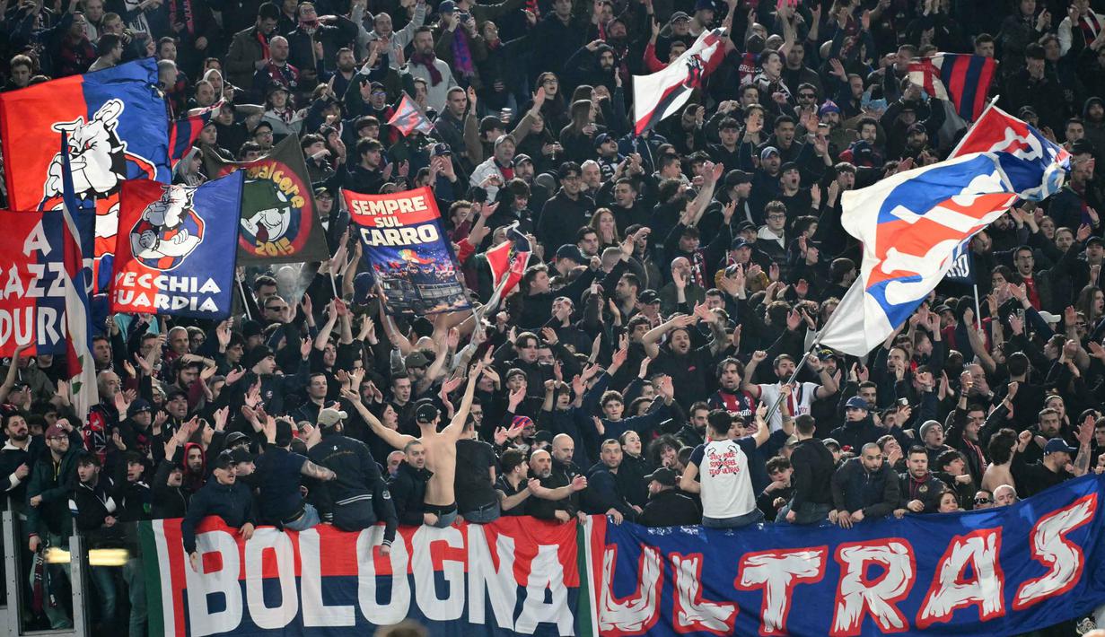 Unggul agregat 5-4, Bologna melaju ke perempat final Liga Europa untuk pertama kali dalam 27 tahun terakhir dan akan menghadapi Aston Villa di perempat final. Tampak dalam foto, para pendukung Bologna bersorak gembira selama menyaksikan pertandingan leg kedua 16 besar Liga Europa 2025/2026 di Stadion Olimpico, Kamis (19/3/2026) waktu setempat atau Jumat 20 Maret 2026 dini hari WIB. (Alberto PIZZOLI/AFP)