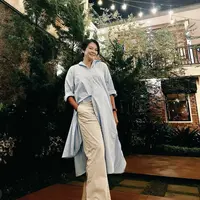 Dian tampil mengenakan atasan kemeja panjang warna baby blue yang dipadukan celana palazzo warna broken white. Credit: Instagram (@bu_deedee)