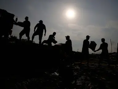 Masyarakat tepi sungai menerima pasokan air dan makanan dari aksi bantuan kemanusiaan negara bagian akibat kekeringan dan suhu tinggi yang melanda wilayah sungai Solimoes, di Careiro da Varzea, negara bagian Amazonas, Brasil, Selasa, 24 Oktober 2023. (AP Photo/Edmar Barros)