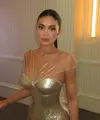 Bak golden barbie modern, Kylie Jenner tampil memukau dalam balutan gaun emas metalik rancangan Ashi Studio. [@makeupbyariel].