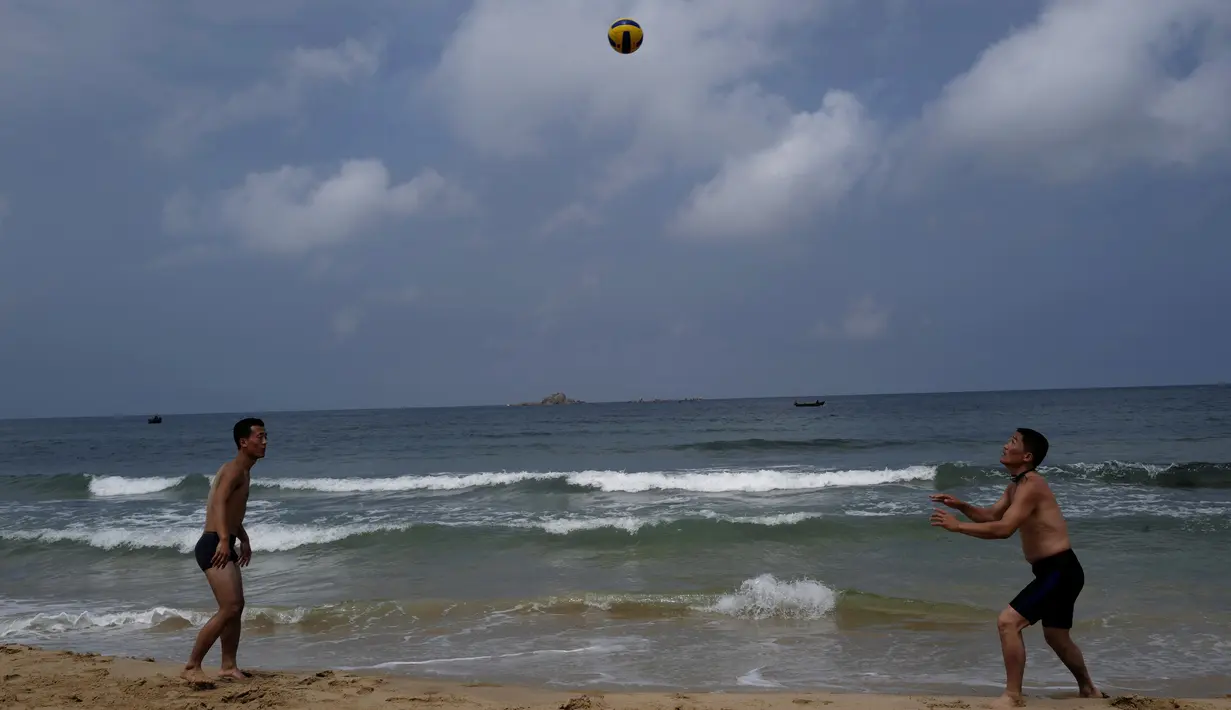 Dua orang bermain bola voli di pantai Sijung Ho di Korea Utara (14/7/2019). Pantai Sijung Ho merupakan tujuan wisata populer bagi penduduk lokal dan asing. (AP Photo/Vincent Yu)