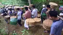 Sejumlah warga membawa tenongan yang berisi makanan saat mengikuti prosesi Sadranan Asyura di makam kiai kramat yang berada di bukit Tlogo Pucang, Kandangan, Temanggung,  Rabu  (12/10).  (Liputan6.com/Gholib)