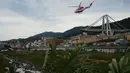 Helikopter tim penyelamat terbang di atas reruntuhan jembatan Morandi di Genoa, Italia, Selasa (14/8). Insiden rubuhnya jembatan Morandi sampai saat ini diperkirakan menelan 30 korban jiwa dan jumlah ini masih bisa bertambah. (AP/Alexander Zemlianichenko)