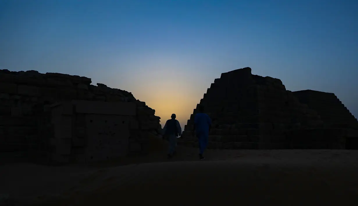 Seorang pengunjung berjalan di antara piramida Meroe di situs arkeologi Meroe di Bejrawiya, Sudan, Sabtu, 1 Agustus 2026. (Foto AP/Mohnd Blal)