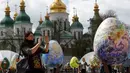 Pengunjung memotret telur Paskah yang dipajang di depan Katedral Mikhaylivsky di pusat Kiev sebelum perayaan Paskah, Ukraina, Rabu (12/4). Sebanyak 500 seniman tradisonal Ukraina terlibat dalam pembuatan telur paskah ini. (AP Photo / Sergei Chuzavkov)