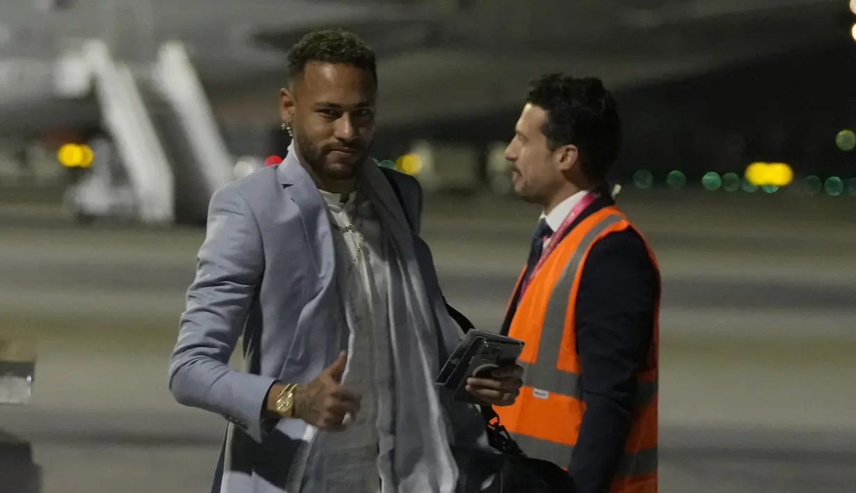 Penyerang Brasil Neymar memberi isyarat saat tiba dengan rekan setimnya menjelang Piala Dunia mendatang di bandara Internasional Hamad di Doha, Qatar, Sabtu (19/11/2022). Penerbangan Amerika Selatan dari Turin di Italia tempat timnas Brasil bermarkas minggu ini mendarat sekitar pukul 23:00 waktu setempat (21:00GMT). (AP Photo/Hassan Ammar)