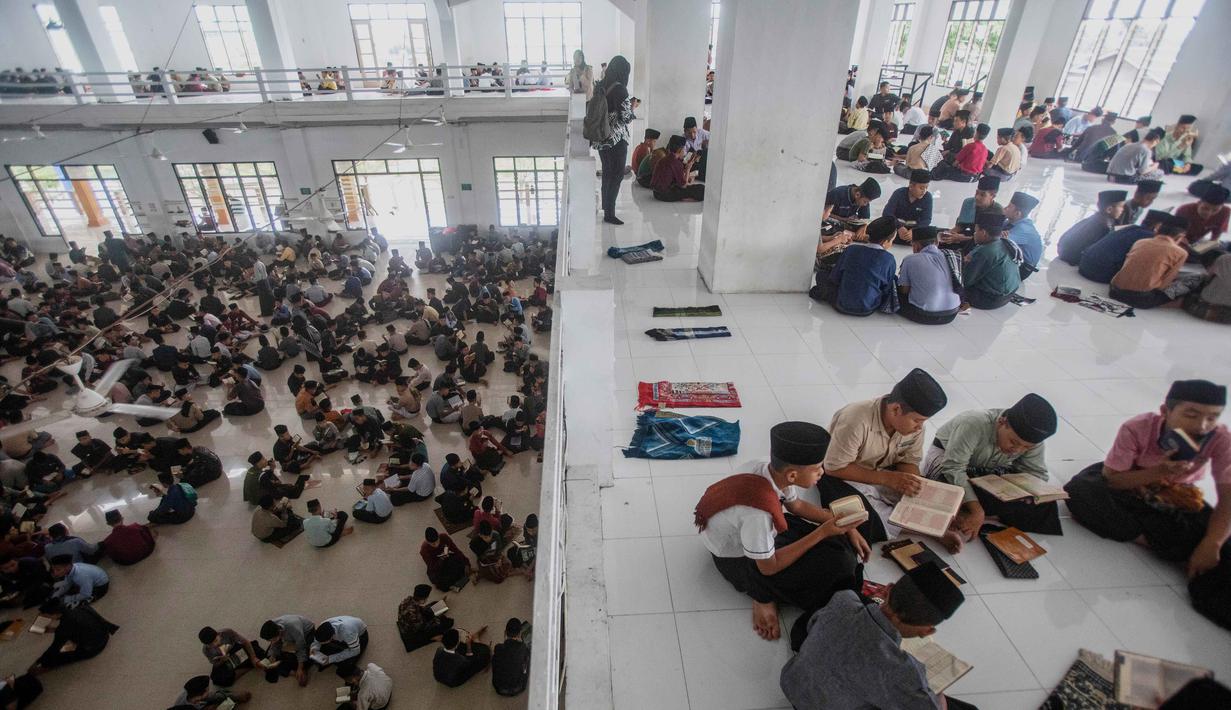 Para siswa duduk melingkar sambil membaca Al-Quran selama bulan suci Ramadan 1447 Hijriah di Pondok Pesantren Ar-Raudlatul Hasanah di Medan, Sumatera Utara, Sabtu 21 Februari 2026. Pelajar atau santri di Pesantren Tarbiyah Islamiyah Ar-Raudlatul Hasanah di Medan, Sumatera Utara, kembali melaksanakan tradisi unik tadarus Al-Quran. (AP Photo/Binsar Bakkara)