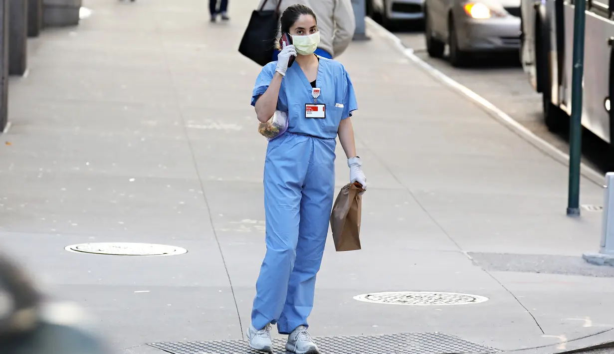Pekerja medis tiba untuk shiftnya di RS NewYork-Presbyterian/Weill Cornell Medical Center selama pandemi COVID-19 di New York City (21/4/2020). COVID-19 telah menyebar ke sebagian besar negara di dunia, lebih dari 175.000 jiwa dengan infeksi lebih dari 2,5 juta orang. (Cindy Ord/Getty Images/AFP)