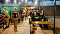Ptugas Satpol PP Pekanbaru membubarkan pengunjung di salah satu kafe karena tidak menerapkan protokol kesehatan Covid-19. (Liputan6.com/M Syukur)