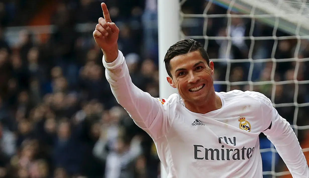 Bintang Real Madrid, Cristiano Ronaldo merayakan gol yang dicetaknya ke gawang Sporting Gijon. CR 7 berhasil menyumbang dua gol pada laga itu. (Reuters/Andrea Comas)
