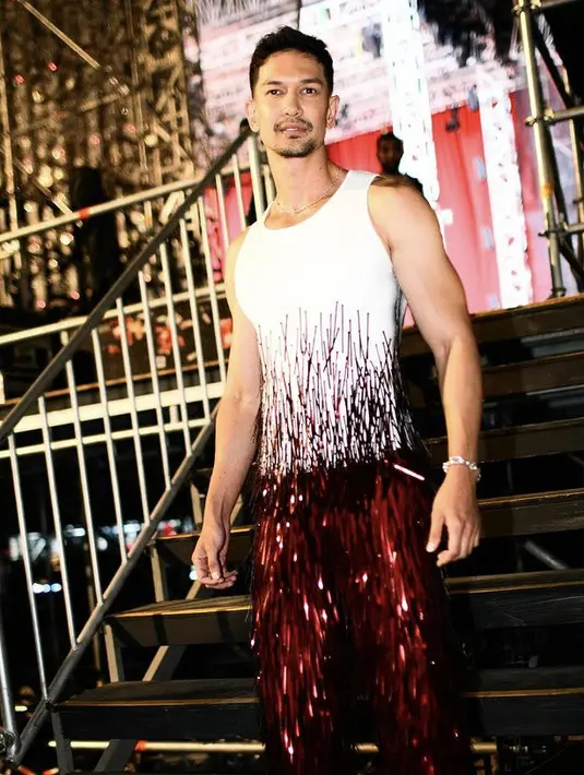 Dimas Beck tampil dengan atasan putih tanpa lengan dengan ansambel rumbai-rumbai serasi dengan celana warna maroonnya dari Monica Ivena. [@dimasbeck]