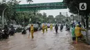 Petugas mengatur lalu lintas saat air menggenangi Jalan Medan Merdeka Barat, Jakarta, Kamis (24/1/2020). Hujan deras yang mengguyur Jakarta sejak pagi tadi mengakibatkan genangan air di Jalan Medan Merdeka Barat. (Liputan6.com/Faizal Fanani)