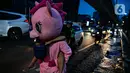 Warkuatno (41) bersama anak sulungnya, Bunga (9) berjalan kaki di pinggir Jalan Raya Fatmawati, Jakarta, Rabu (6/1/2021). Mantan sopir Metromini 75 ini menjadi badut keliling sejak bulan Maret lalu, tak lama setelah kasus corona COVID-19 terdeteksi di Indonesia. (Liputan6.com/Faizal Fanani)