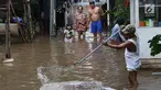 Warga membersihkan banjir yang menggenangi kawasan Cilandak Timur, Jakarta Selatan, Selasa (22/1). Hujan deras yang mengguyur Jakarta dan sekitarnya sejak pagi menyebabkan banjir di sejumlah sudut Ibu Kota. (Liputan6.com/Immanuel Antonius)