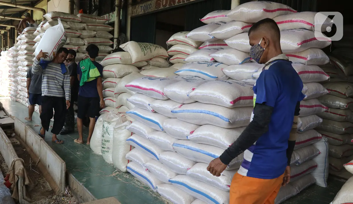 Buruh membawa karung beras di pasar induk beras Cipinang, Jakarta, Sabtu (16/5/2020). Mengantisipasi penyebaran Covid-19 sejumlah kuli dan buruh di Pasar Induk beras Cipinang diberi obat herbal mentah untuk meredakan panas. (Liputan6.com/Herman Zakharia)
