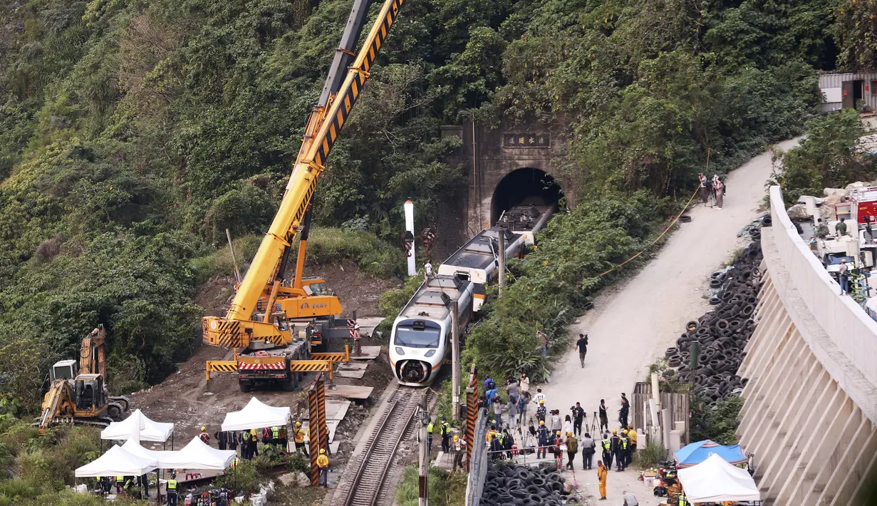 Petugas penyelamat memindahkan bagian dari kereta yang tergelincir dekat Ngarai Taroko di Hualien, Taiwan, Sabtu (3/4/2021). Kereta delapan gerbong yang berisi 494 orang itu berangkat dari Taipei menuju Taitung saat kecelakaan. (AP Photo/Chiang Ying-ying)