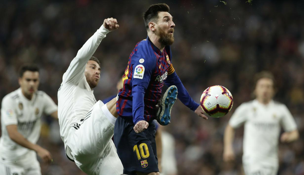 Striker Barcelona, Lionel Messi, berebut bola dengan bek Real Madrid, Sergio Ramos, pada laga La Liga di Stadion Santiago Bernabeu, Sabtu (2/3). Real Madrid takluk 0-1 dari Barcelona. (AP/Manu Fernandez)