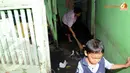 Seorang ibu tampak menyapu sampah yang masuk ke dalam rumah (Liputan6.com/Faisal R Syam)