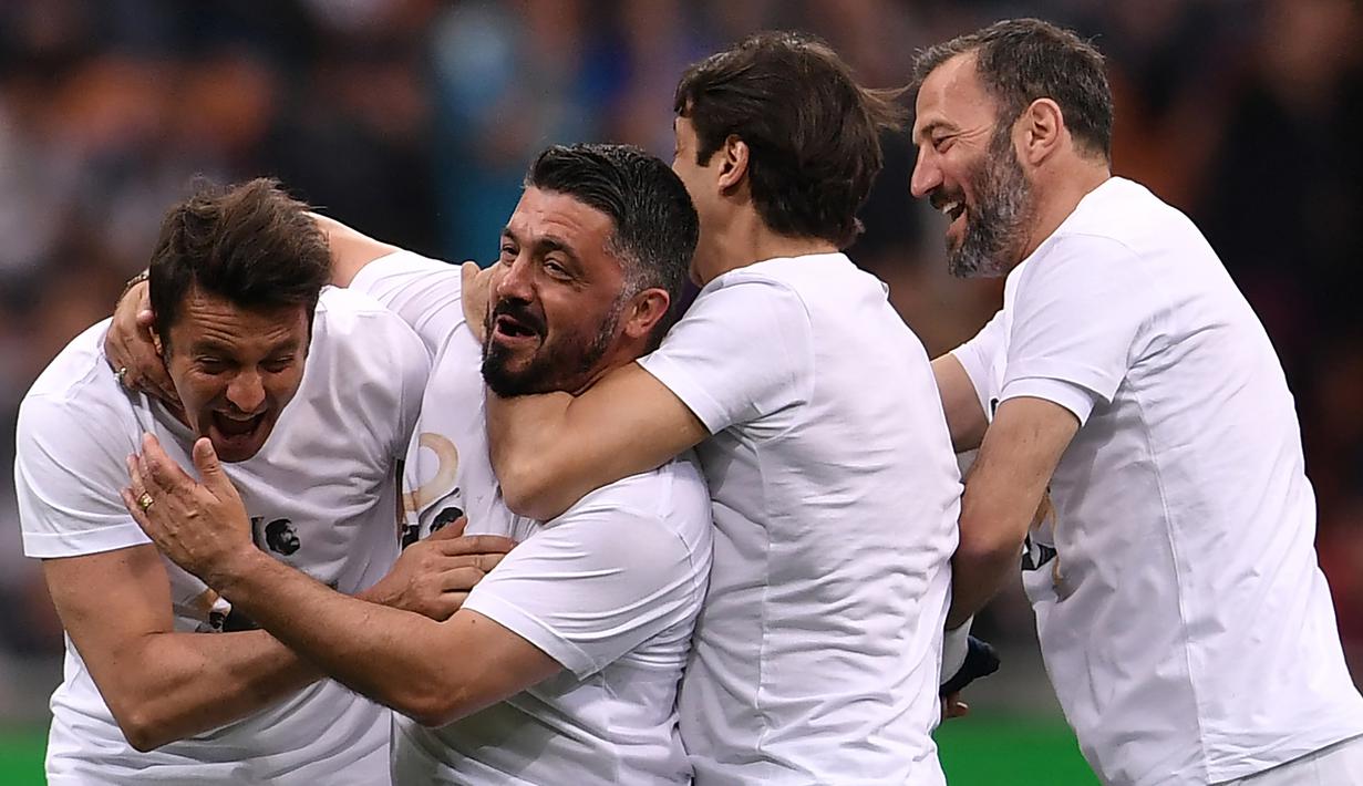 Mantan pemain Timnas Italia, Massimo Oddo, bercanda dengan Gennaro Gattuso pada laga Notte del Maestro di Stadion Giuseppe Meazza, Milan, Senin (21/5/2018). Laga ini merupakan seremoni gantung sepatu dari Andrea Pirlo. (AFP/Marco Bertorello)