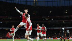 Gelandang Arsenal, Martin Odegaard (melompat), merayakan gol yang dicetaknya ke gawang Luton Town bersama rekan setimnya yang memberikan assist, Kai Havertz, dalam laga pekan ke-21 Premier League 2023/2024 di Emirates Stadium, Kamis (4/4/2024) dini hari WIB. Arsenal menang 2-0 dalam laga ini. (Adrian DENNIS / AFP)