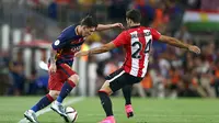 Pemain Barcelona, Lionel Messi berusaha melewati pemain Athletic Bilbao, Mikel Balenciaga pada laga Piala Super Spanyol di Stadion Camp Nou, Spanyol, Senin (17/8/2015). (EPA/Toni Albir)