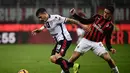 Bek AC Milan, Davide Calabria mencoba menghentikan pergerakan pemain Cagliari pada laga lanjutan Serie A yang berlangsung di stadion San Siro, Milan, Senin (11/2). AC Milan menang 3-0 atas Cagliari. (AFP/Marco Bertorello)
