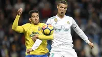 Cristiano Ronaldo (kanan) berebut bola dengan pemain Las Palmas, Pedro Bigas Rigo pada laga La Liga Santander di Santiago Bernabeu stadium, Madrid, (5/11/2017). Real Madrid menang 3-0. (AFP/Gabriel Bouys)