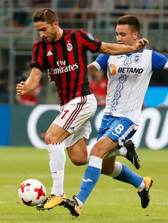 Penyerang AC Milan, Fabio Borini berusaha membawa bola dari kawalan pemain U Craiova, Alexandru Mateiu saat bertanding di leg kedua babak 3 Liga Europa di San Siro, Milan, (3/8). AC Milan sukses menang 2-0 atas Craiova. (AP Photo/Antonio Calanni)