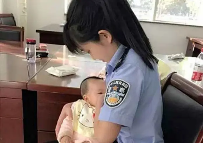 Seorang petugas pengadilan menyusui anak perempuan yang tengah diadili. (China Daily/Asia News Network)