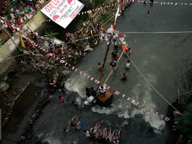 Sejumlah warga memadati bantaran Kali Code untuk menyaksikan lomba panjat pinang, Yogyakarta, Selasa (9/8). Lomba diselenggarakan untuk menyambut HUT RI ke-71. (Liputan6.com/Boy Harjanto)