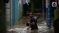 Warga beraktivitas di tengah banjir yang merendam kawasan Kebon Pala, Kampung Melayu, Jakarta Timur, Sabtu (16/7/2022). Meskipun ketinggian air sudah mencapai paha orang dewasa, warga setempat belum memutuskan untuk mengungsi. (merdeka.com/Imam Buhori)