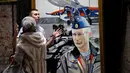 Dua orang pengunjung melihat lukisan yang bergambar Presiden Rusia Vladimir Putin dalam pameran Superputin di Museum Umam, Moskow (6/12). (AFP Photo/Yuri Kadobnov)