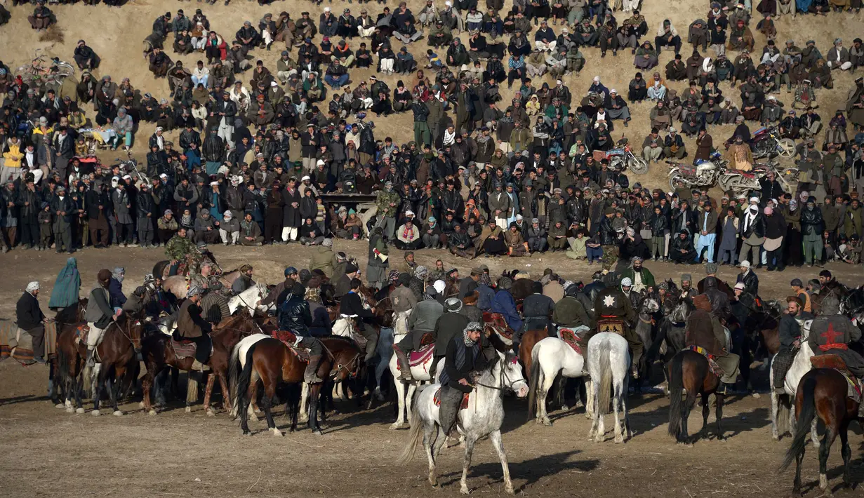 Para penunggang kuda Afghanistan bersaing memperebutkan bangkai saat pertandingan olahraga tradisional Buzkashi di Mazar-i-Sharif, Afghanistan (20/12). Buzkashi adalah olahraga tradisional yang cukup populer di kawasan Asia Tengah. (AFP/Farshad Usyan)