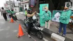 Ojek online (ojol) menerima bantuan berupa bingkisan makan siang dan hand sanitizer di kawasan Jalan Raden Saleh, Jakarta, Selasa (7/3/2020). Bantuan dari DPP PKB guna meringankan beban ojol yang sepi orderan akibat lesunya perekonomian selama pandemi corona Covid-19. (Liputan6.com/Fery Pradolo)