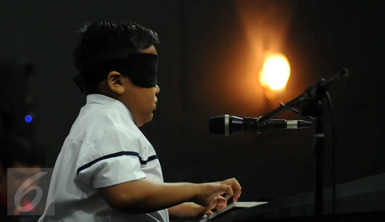 Jefri Setiawan saat memainkan keyboard di Auditorium Kemenpora, Jakarta, Kamis (14/11). Jefri  akan memainkan 50 lagu selama 5 jam nonstop dengan mata tertutup. (Liputan6.com/Helmi  Fithriansyah)
