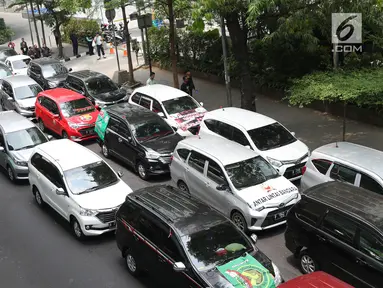 Ratusan kendaraan taksi online yang tergabung Aliansi Nasional Driver Online Indonesia berjejer di jalan Iskandarsyah menuju Terminal Blok M, Jakarta, Selasa (25/9). Mereka berunjuk rasa di depan Kantor GO-JEK Indonesia. (Liputan6.com/Helmi Fithriansyah)