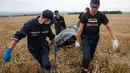 Para petugas juga membawa sisa puing untuk keperluan penyidikan. Ukraina menuduh pemberontak Rusia dan pro-Moskow menghancurkan bukti kejahatan dari sisa reruntuhan pesawat (REUTERS/Maxim Zmeyev).