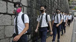 Para siswa sekolah mengenakan topeng dan helm berjalan di luar St. Paul's College selama protes di Hong Kong, Selasa (3/9/2019). Puluhan ribu siswa di Hong Kong memprotes terhadap gerakan anti-pemerintah. (AP Photo/Kin Cheung)