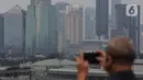 Deretan gedung bertingkat tersamar kabut polusi udara di Jakarta, Selasa (20/4/2021). Berdasarkan data "World Air Quality Index" pada Selasa (20/4) pukul 10.00 WIB tingkat polusi udara di Jakarta menunjukkan kualitas udara di Ibu Kota termasuk kategori tidak sehat.  (Liputan6.com/Johan Tallo)